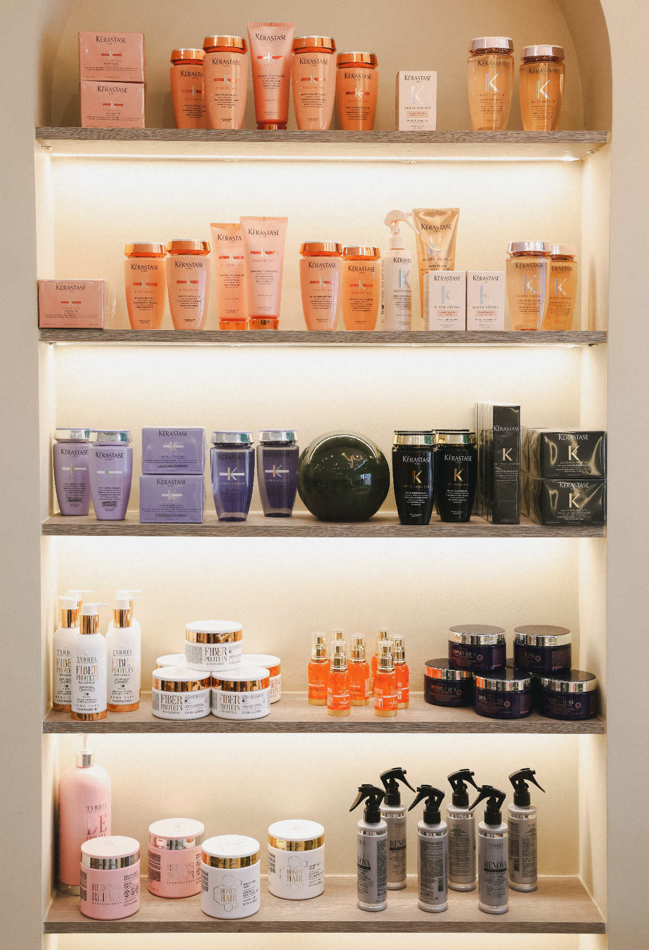 A curated display of Kérastase and professional haircare products on illuminated salon shelves